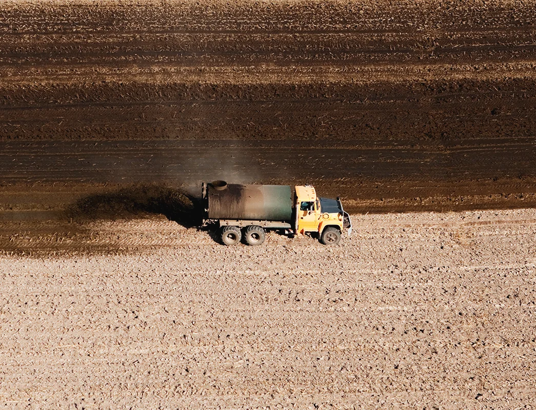 A tank truck spreading manure on a recently harvested corn field. In Europe, animal farming generated annually more than 1.4 billion tonnes of manure between 2016–2019, which more than 90% is directly re-applied to soils as organic fertiliser, but if pollu